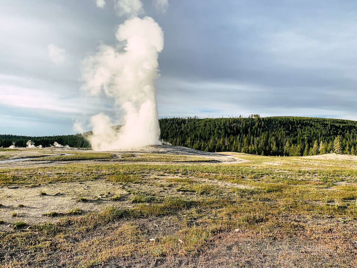 Old Faithful geyser erupting against a blue sky in Yellowstone National Park