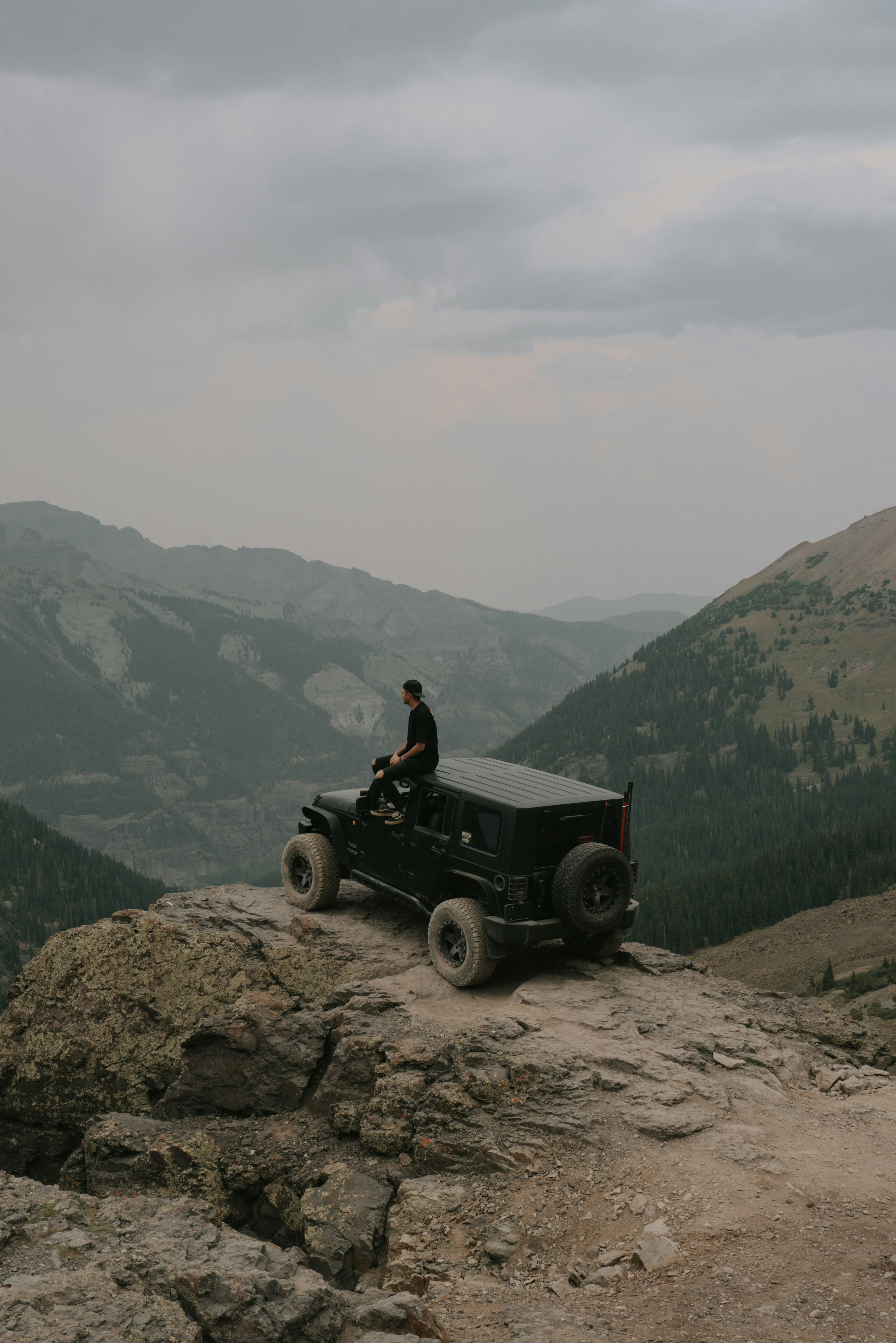 Jeep on a rocky mountain ridge in Colorado, USA, with mountain valley views