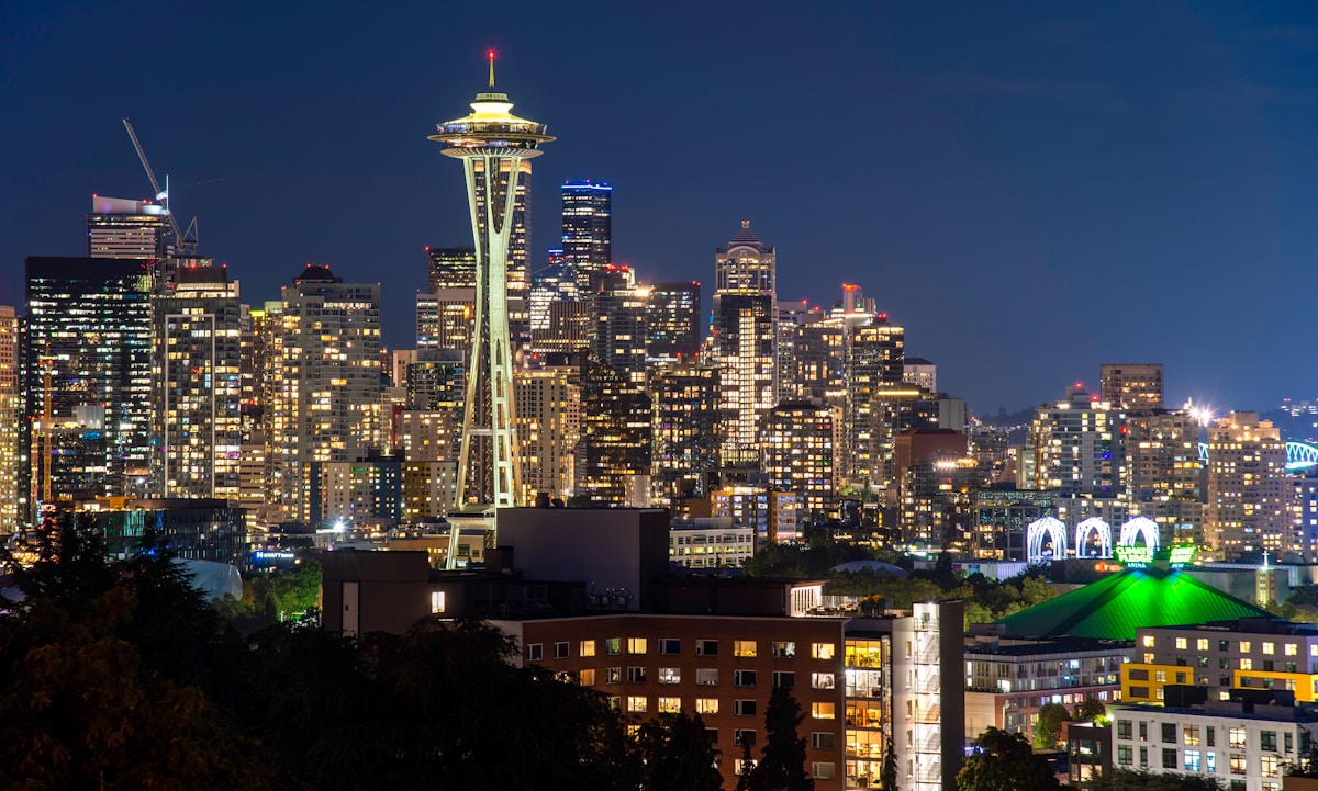 A hotel room with floor-to-ceiling windows overlooking Puget Sound and the Olympic Mountains in Seattle